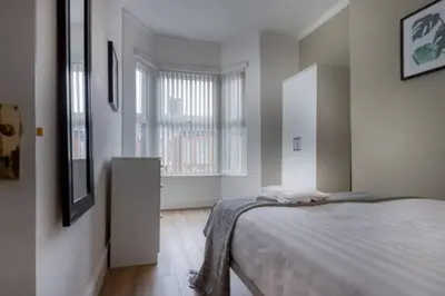 a bedroom with a bed and a large window at Vibrant Artist Hideaway by Centre Parking in Liverpool