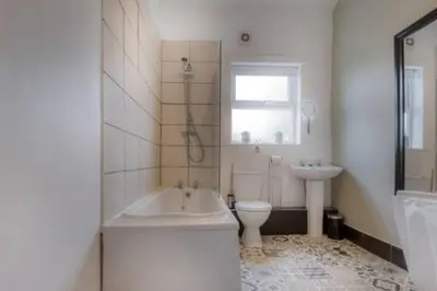 a bathroom with a tub and a toilet and a sink at Vibrant Artist Hideaway by Centre Parking in Liverpool
