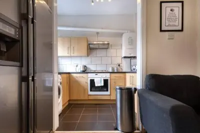 a small kitchen with a stainless steel refrigerator at Vibrant Artist Hideaway by Centre Parking in Liverpool