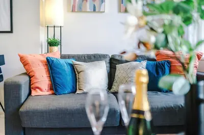 a living room with a couch with pillows and wine glasses at NEW! Stunning City Centre 2-bed apartment in Liverpool by 53 Degrees Property, Ideal for Small Groups, Sleeps 6! in Liverpool