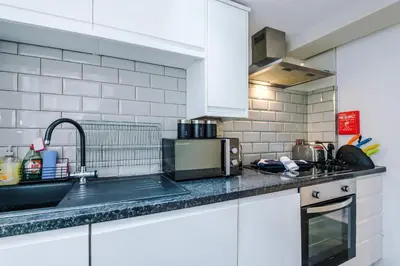 a white kitchen with a sink and a microwave at NEW! Stunning City Centre 2-bed apartment in Liverpool by 53 Degrees Property, Ideal for Small Groups, Sleeps 6! in Liverpool