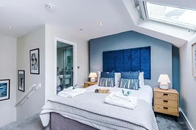 a bedroom with a large bed with a blue headboard at NEW! Stunning City Centre 2-bed apartment in Liverpool by 53 Degrees Property, Ideal for Small Groups, Sleeps 6! in Liverpool