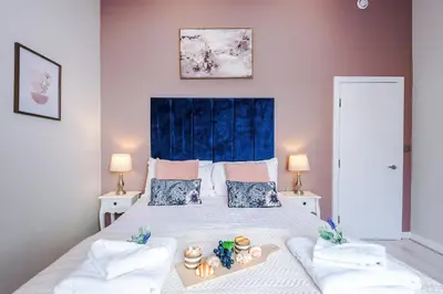 a bedroom with a large bed with a blue headboard at NEW! Stunning City Centre 2-bed apartment in Liverpool by 53 Degrees Property, Ideal for Small Groups, Sleeps 6! in Liverpool