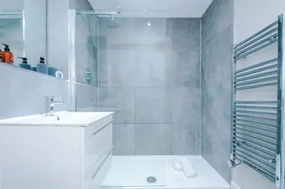 a white bathroom with a sink and a shower at NEW! Stunning City Centre 2-bed apartment in Liverpool by 53 Degrees Property, Ideal for Small Groups, Sleeps 6! in Liverpool