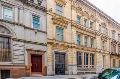 a large building with a red door on a street at NEW! Stunning City Centre 2-bed apartment in Liverpool by 53 Degrees Property, Ideal for Small Groups, Sleeps 6! in Liverpool