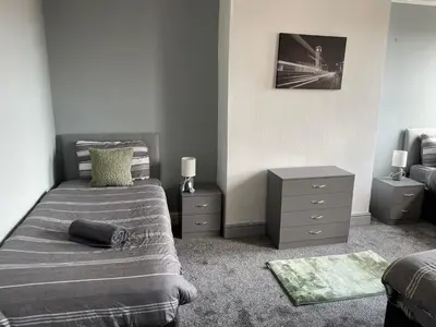 a bedroom with a bed and a dresser and a bed sidx sidx sidx sidx at The Clifton Guest House in Liverpool