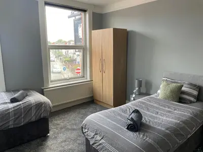 a bedroom with two beds and a window at The Clifton Guest House in Liverpool