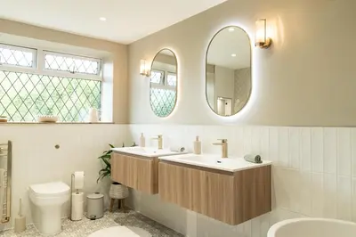 a bathroom with two sinks and a toilet and a mirror at Heather room at field view cottage in Eccleston