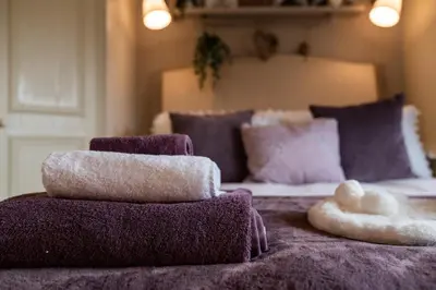 a bed with three pillows and a stuffed animal on it at Heather room at field view cottage in Eccleston