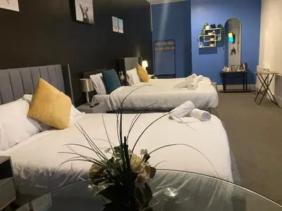 a room with two beds and a glass table at North Coast Hotel in Blackpool