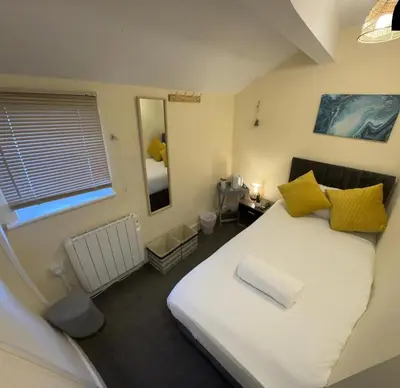 a bedroom with a large white bed with yellow pillows at North Coast Hotel in Blackpool
