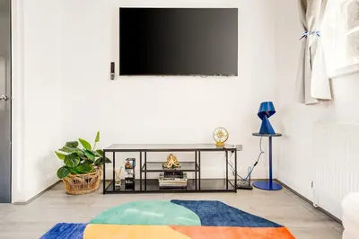 a living room with a tv on a white wall at Stylish Prime Location Apartment by VICHY in Liverpool