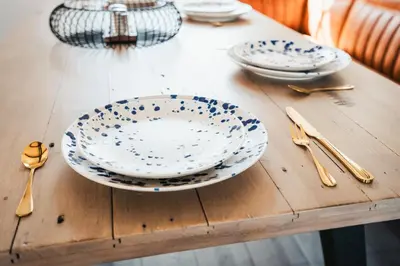 two plates and spoons on a wooden table at Stylish Prime Location Apartment by VICHY in Liverpool