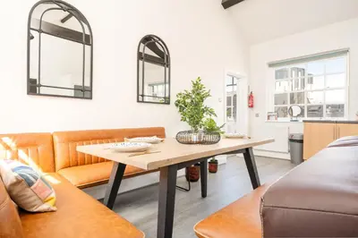 a living room with a table and a couch at Stylish Prime Location Apartment by VICHY in Liverpool