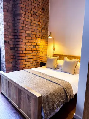 a bedroom with a bed with a brick wall at Stylish Loft Apartament - City Center L1 in Liverpool