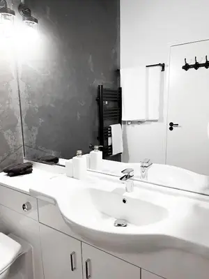 a white bathroom with a sink and a mirror at Stylish Loft Apartament - City Center L1 in Liverpool