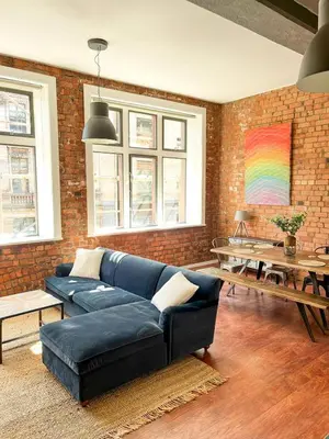 a living room with a blue couch and a brick wall at Stylish Loft Apartament - City Center L1 in Liverpool