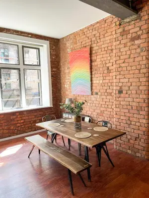 a room with a wooden table and a brick wall at Stylish Loft Apartament - City Center L1 in Liverpool