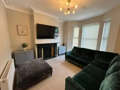 a living room with a couch and a fireplace at Casa Arkles - next to stadium - free parking in Liverpool