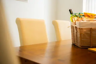a table with two chairs and a basket of food at Casa Arkles - next to stadium - free parking in Liverpool
