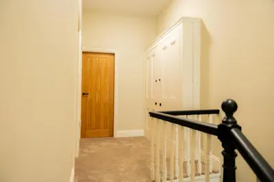 a hallway with a staircase and a wooden door at Casa Arkles - next to stadium - free parking in Liverpool