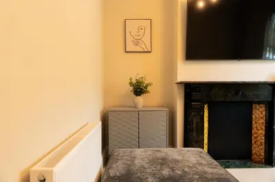 a living room with a table and a fireplace at Casa Arkles - next to stadium - free parking in Liverpool