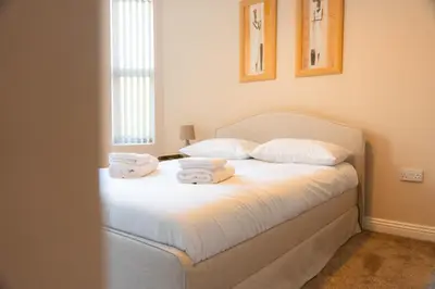a bedroom with a bed with towels on it at Casa Arkles - next to stadium - free parking in Liverpool
