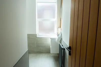 a small bathroom with a sink and a window at Casa Arkles - next to stadium - free parking in Liverpool
