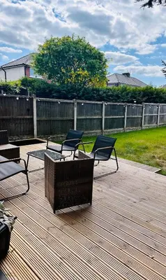 two chairs and a table on a wooden deck at Everythings Cosy at Clucas in Ormskirk