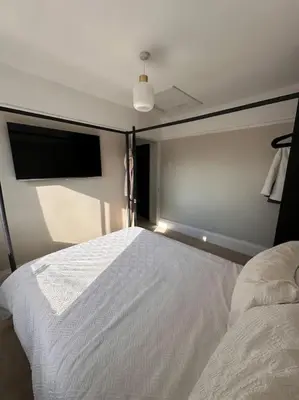 a bedroom with a white bed and a flat screen tv at Everythings Cosy at Clucas in Ormskirk