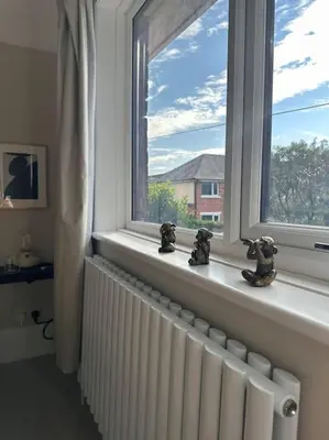 a window with three cats figurines sitting on a radiator at Everythings Cosy at Clucas in Ormskirk