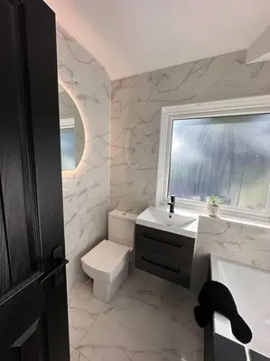 a bathroom with a toilet and a sink and a window at Everythings Cosy at Clucas in Ormskirk