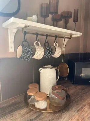 a tray with cups and utensils on a shelf at Everythings Cosy at Clucas in Ormskirk
