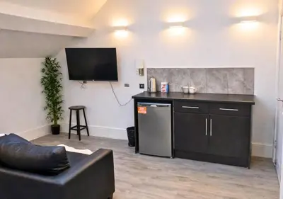 a living room with a couch and a tv on a wall at Williamson 2 Bedroom City Centre sleeps 10 in Liverpool