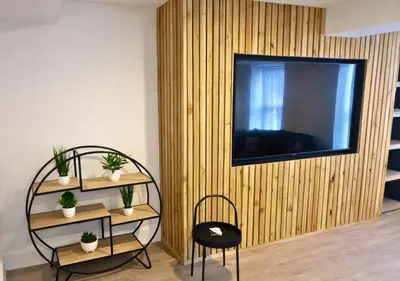 a living room with a television on a wooden wall at Williamson 2 Bedroom City Centre sleeps 10 in Liverpool