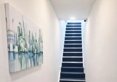 a stairway with a painting on the wall and a stair case at Williamson 2 Bedroom City Centre sleeps 10 in Liverpool
