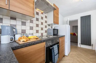 a kitchen with a stove and a plate of bread at Manor Terrace Retreat in Accrington