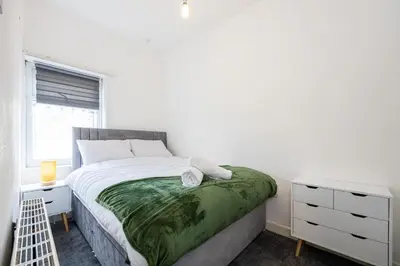 a white bedroom with a bed and a window at Manor Terrace Retreat in Accrington