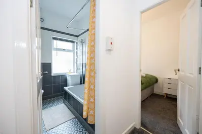 a bathroom with a blue bath tub and a window at Manor Terrace Retreat in Accrington