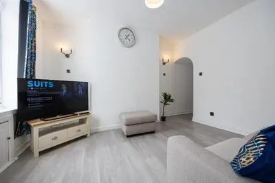 a living room with a tv and a couch at Manor Terrace Retreat in Accrington