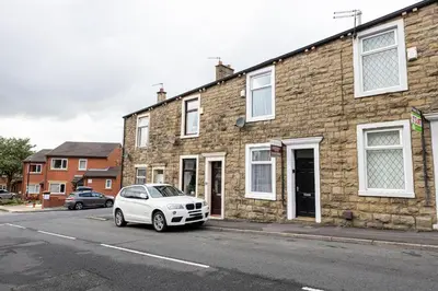 a white car parked in front of a brick building at Manor Terrace Retreat in Accrington
