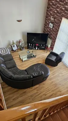 a living room with a black couch and a television at Open planned apartment in Birkenhead