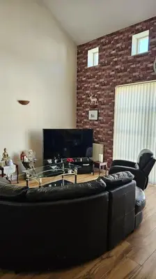 a living room with a black couch and a tv at Open planned apartment in Birkenhead
