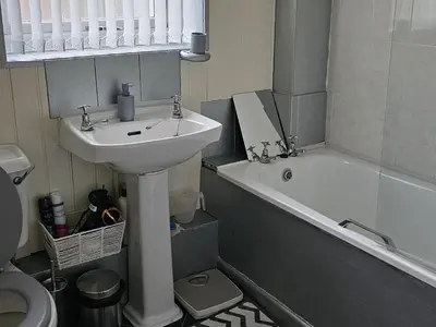 a bathroom with a sink and a toilet and a bath tub at Open planned apartment in Birkenhead