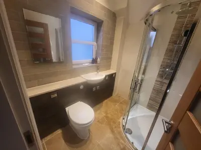 a bathroom with a toilet and a sink and a shower at Anchor Gardens Villa in Lindal in Furness