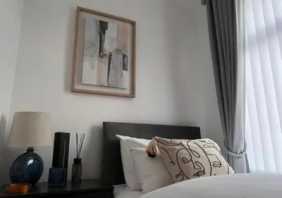 a bedroom with a bed and a picture on the wall at Spacious Home - Sleeps 5 persons - Minutes Walk from Anfield Stadium in Liverpool