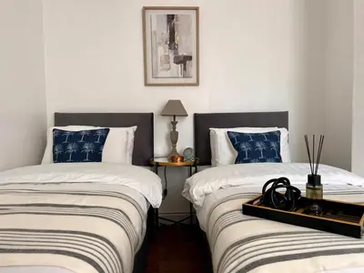 two beds sitting next to each other in a bedroom at Spacious Home - Sleeps 5 persons - Minutes Walk from Anfield Stadium in Liverpool