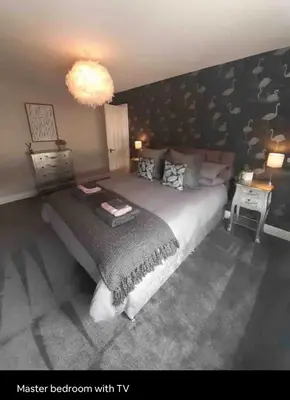 a bedroom with a large bed and a chandelier at Seaside Suites in Blackpool