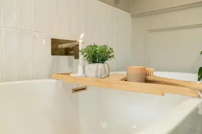 a bathroom with a wooden shelf with a candle and a plant at Fern room at field view cottage in Eccleston