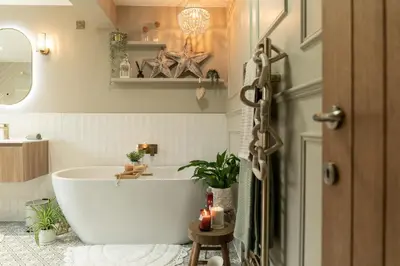 a bathroom with a white tub and a plant at Fern room at field view cottage in Eccleston